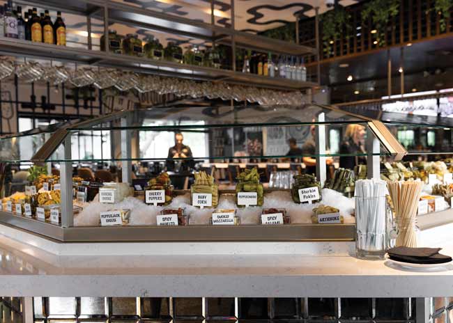 The build-your-own Bloody Mary bar features more than 50 different garnish options. It’s the center of the Hash experience and the physical center of the design.