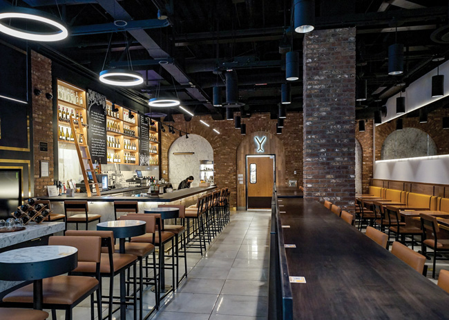 Vyne Washington Tasting Room at Seattle-Tacoma International Airport, designed by MG2, sets the bar in the heart of the space. Image courtesy of MG2