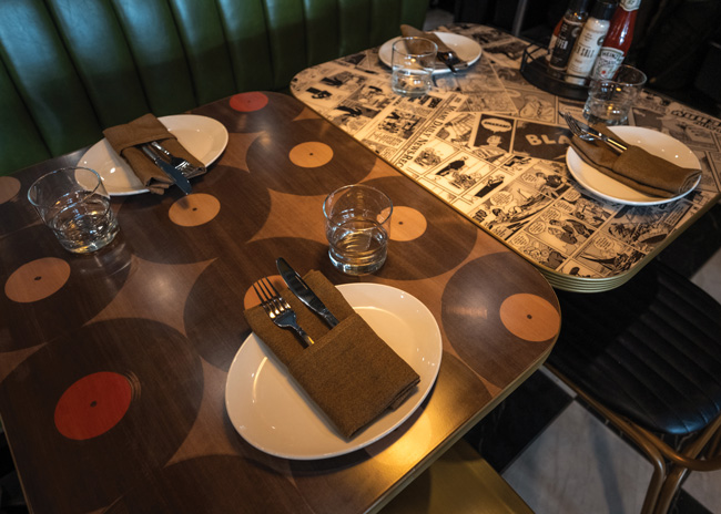 Tabletops with music-related and vintage cartoon strip artwork, customized to include local Sarasota references, add to the fun period vibe.
