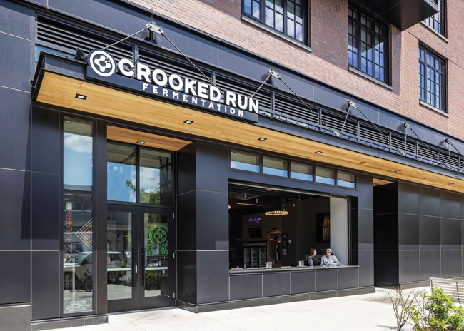 The wood-style finish on the underside of the canopy came with the building but aligned with the wooden finishes Crooked Run wanted in this new location. The company added a matching finish to its recessed entryway.