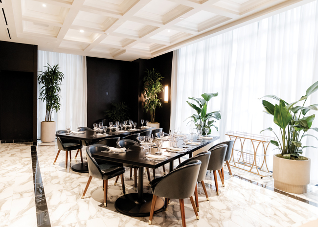 The private dining area stands out through coffered ceilings and a different pattern to the marble-tiled floor.
