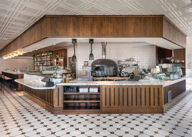 Mother Pizza’s imported gas pizza oven adds aesthetic focal point behind the counter. Image courtesy of Nat Rea Photography