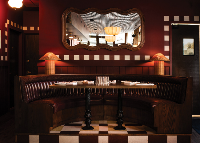 Classic 1950s automobile aesthetics show up in the upholstery detailing of a clamshell booth at the back of the restaurant.