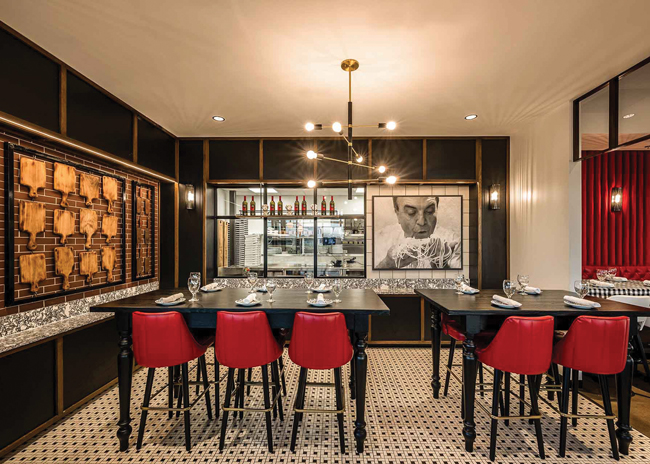 With a large photo of a chef handling pasta and cutting boards displayed on a wall, Harrison’s design at the Sicilian Butcher in Dallas creates a memorable environment. Image by Matthew  Glac, MG Fotografix LLC